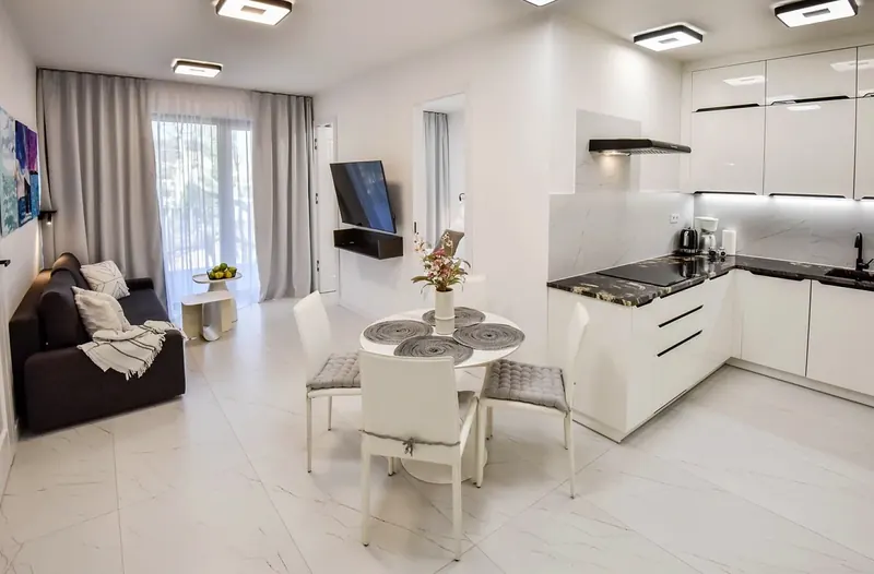 Světlý obývací pokoj s kuchyňským koutem v apartmánu Greeneri Park